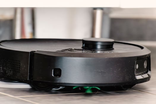 Robot vacuum cleaner with dust, real life photo, saves time and goes into hard-to-reach places, helper photo