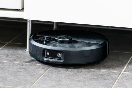 Robot vacuum cleaner with dust, real life photo, saves time and goes into hard-to-reach places, industry photo