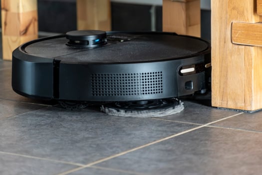 Robot vacuum cleaner with dust, real life photo, saves time and goes into hard-to-reach places, cleaning photo