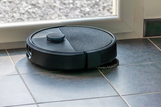 Robot vacuum cleaner with dust, real life photo, saves time and goes into hard-to-reach places, tech photo
