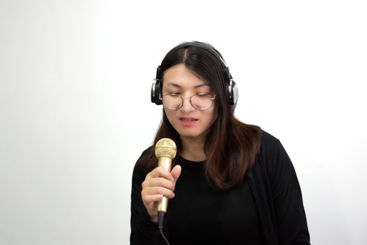 A woman wearing headphones and holding a microphone photo