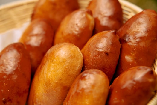 Freshly baked filipino bread pandesal rolls in brown basket photo