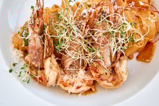 Gourmet prawn pasta with sprouts on white plate photo