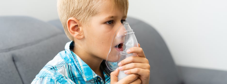Treatment at home of a toddler. A boy is using nebuliser. photo