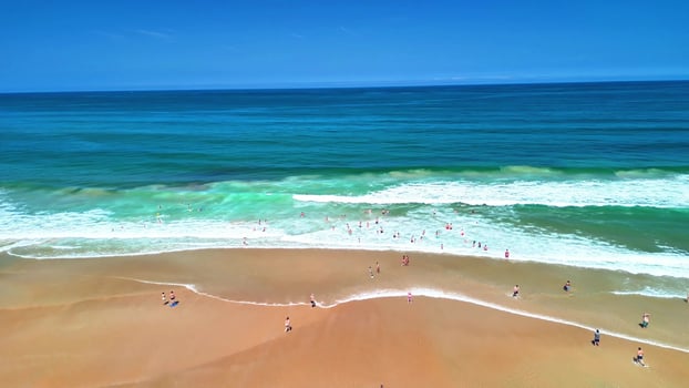 A stunning beach scene with mesmerizing turquoise waters, rolling waves, and sunbathers delighting in the warm su photo