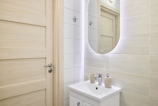 This is a Modern Bathroom featuring a Stylish Sink and an Illuminated Mirror for ambiance photo