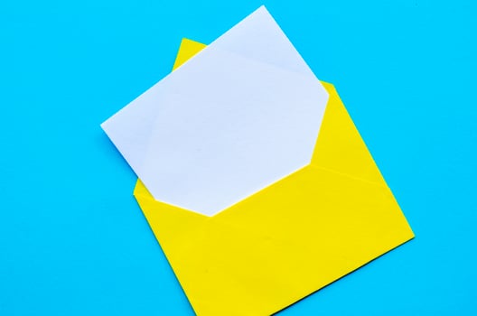 Top view of white notepad with envelope on blue cover background with customizable space for text or ideas. photo