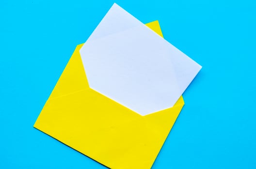 Top view of white notepad with envelope on blue cover background with customizable space for text or ideas.. photo