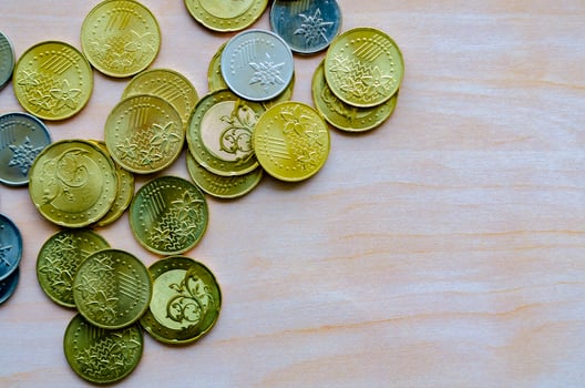 Piled coins on desk surface with customizable space for text or ideas photo