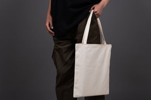 Front View of Woman Holding Blank Canvas Tote Bag, Eco-Friendly Reusable Fabric with Handle, Close-Up Mockup, No Plastic and Environmental Concept Fashion photo