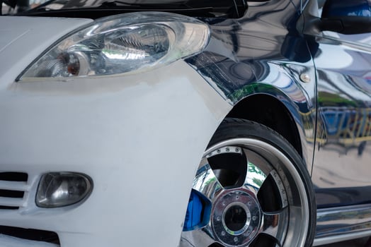 A close up of a white car with a blue rim photo