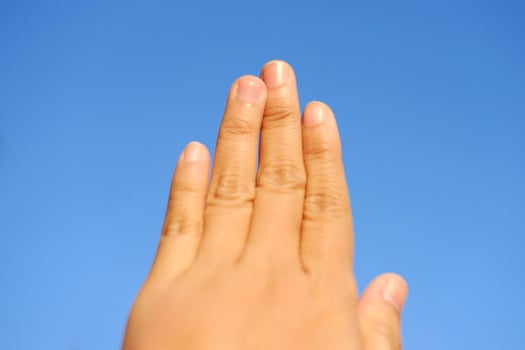 Close up finger of woman hand on blue sky photo