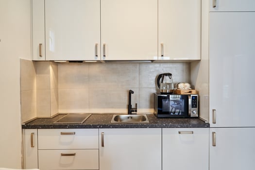 Modern kitchen with white cabinets and black countertop photo