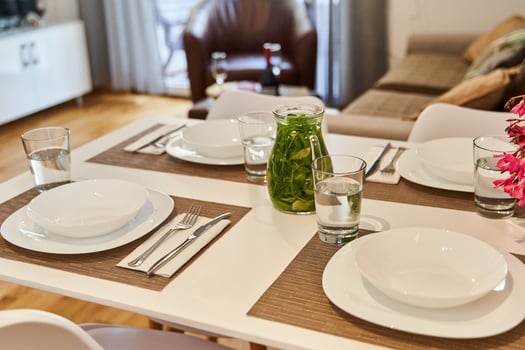 Elegant dining table setup with glass jars and cutlery in modern living room photo
