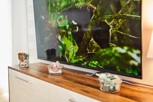 Modern living room flat-screen tv on wooden stand with decorative stones photo
