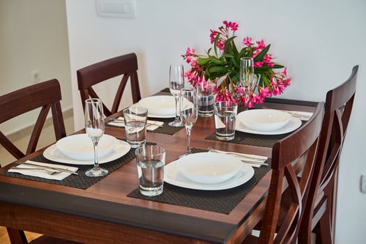 Elegant dining table setting with flowers and four place settings in a modern home photo