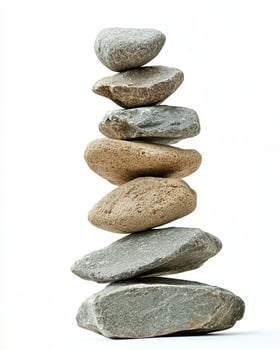 A stack of seven smooth stones balanced on top of each other against a white background photo