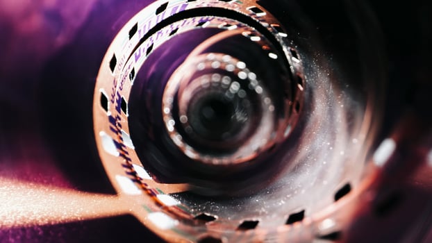 An old twisted color film lies on a dark background, symbolizing memories on the film. The film appears aged with faded colors and curled edges, evoking nostalgia and a vintage feel photo