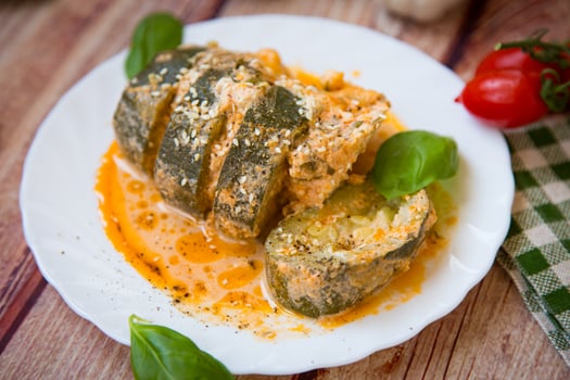 Zucchini pieces in a hot sauce on a white plate photo