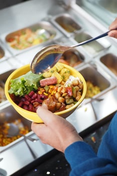 Creating a colorful bowl of mixed ingredients at a salad bar photo