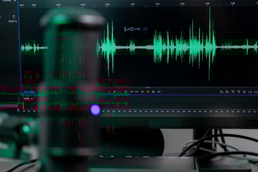 Professional desktop microphone with vibrant green audio waveform on monitor, illustrating sound engineering, podcasting, and digital content creation photo