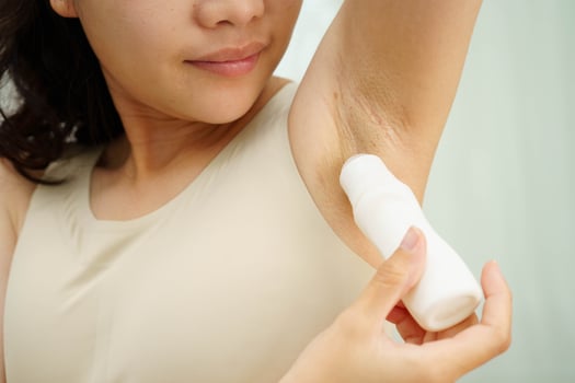 Asian young woman applying roll on deodorant reduce underarm sweat and odor after shower. photo