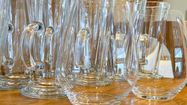 Translucent glassware symphony on wooden table, echoing Oktoberfest jubilance, artisanal European craftsmanship, and ethereal holiday reflections photo