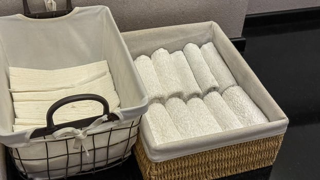 Crisp folded towels in woven baskets evoke spa like tranquility, perfect for Hygge rituals or spring cleaning renewal photo