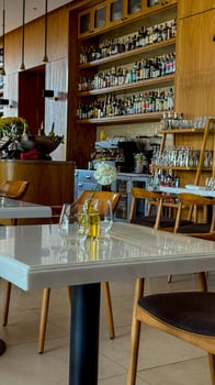 Upscale cafe with elegant white roses, polished wood, and eclectic bottle display, ideal for International Coffee Day reflections photo