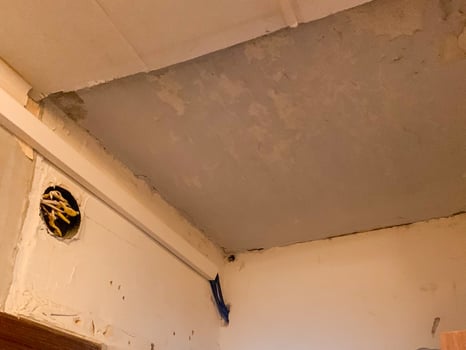Rustic ceiling corner with peeling paint, evoking vintage charm ideal for Retro Renovation Day or artistic photo exhibits