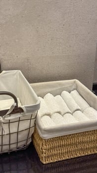 Neatly rolled white towels nestle in wicker baskets, evoking Hygge coziness and spring cleaning rituals, perfect spa elegance photo