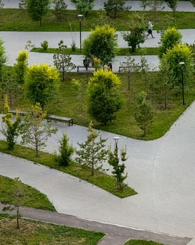Paved labyrinth amid whispering trees, an Asian male jogger embraces serene urban harmony, perfect for Silent Walk Day photo