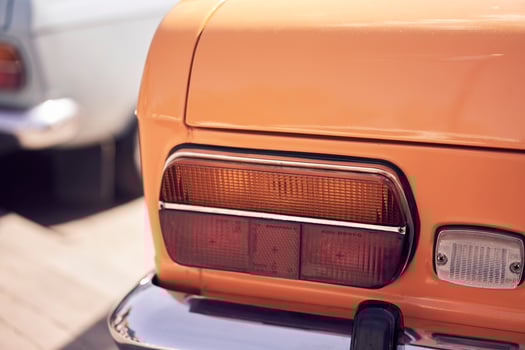 A vintage car tail light illuminates a cobbled street, embodying classic automotive aesthetics photo