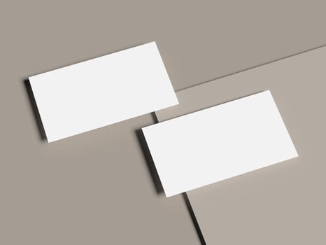 Bright business cards over pale yellow and soft gray layered paper photo