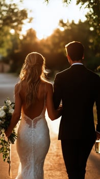 Newlyweds Walk Hand in Hand Toward Sunset After Outdoor Wedding Ceremony photo
