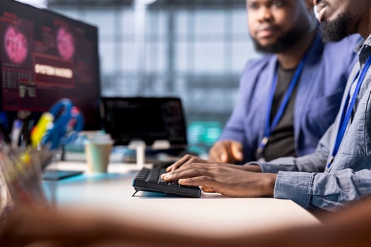 African american server farm worker trying to protect hardware from hacker attack stealing info. Man in data center workplace trying to get rid of virus after seeing security breach alert on display photo