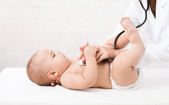 Medical check up. Pediatrician listening to baby's lungs and heart, close up photo