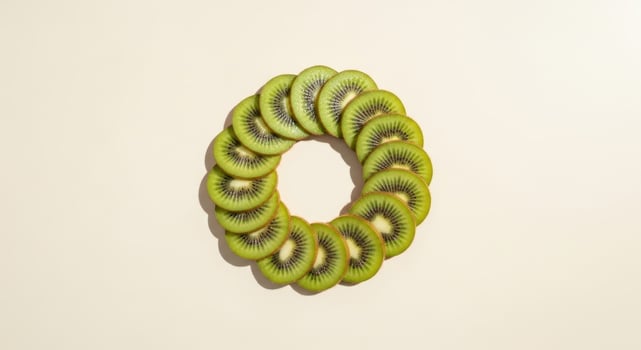 Kiwi slices arranged in a circular wreath on a plain background photo