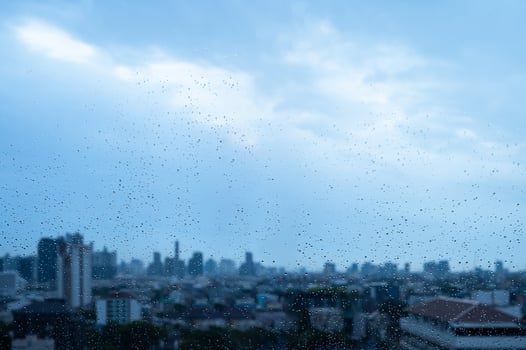 Raindrops on glass with soft city silhouette when monsoon season background. photo