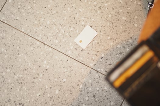 Card dropped on tiled floor near wallet during busy day photo