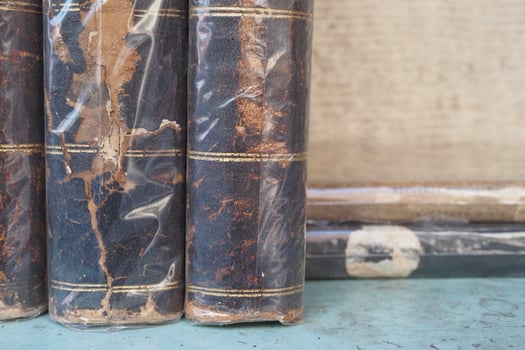 Old leather-bound books stacked on a wooden table photo