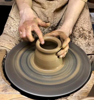 Hands of master shape clay pot on a potters wheel. Closeup. photo