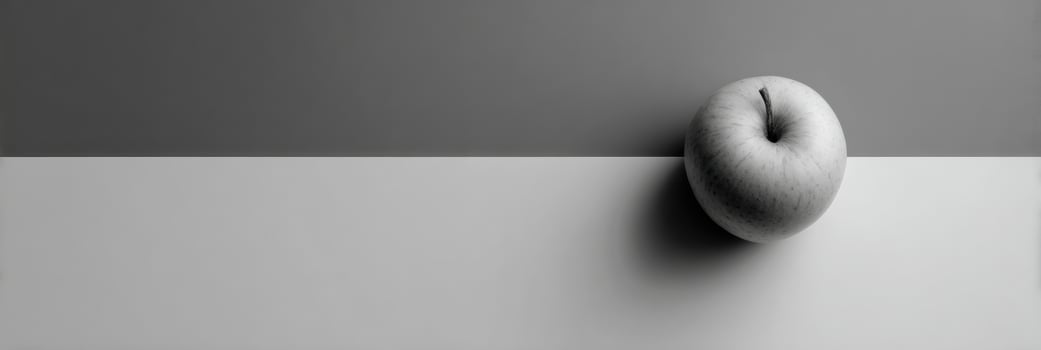Minimalist Grayscale Composition Featuring a Single Colored Apple Against an Empty Right Side Background photo