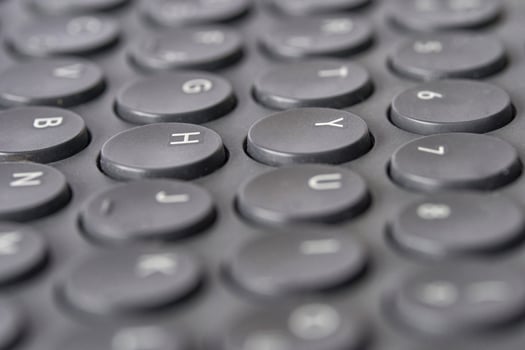 Close up of black round keyboard keys with alphabet and numerals. photo