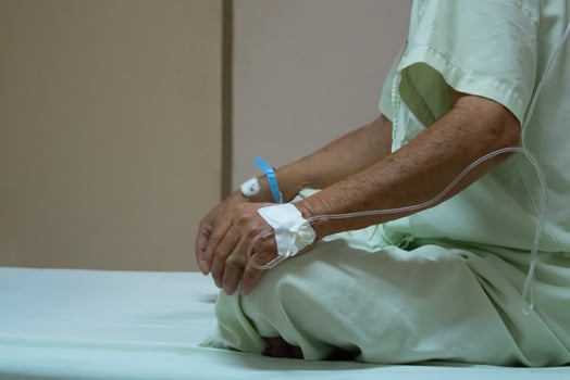 A man in a hospital bed with an iv photo