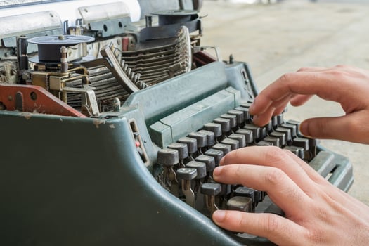 A person typing on an old typewriter photo