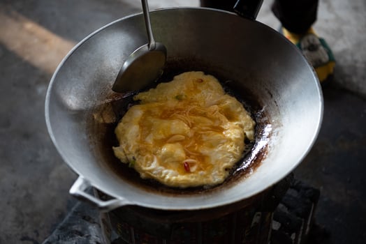 A person stirring a pan with a spoon photo
