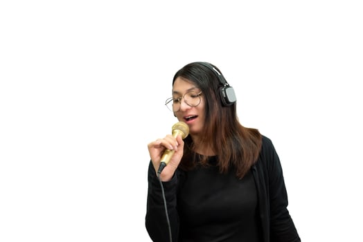 A woman with headphones and a microphone singing photo