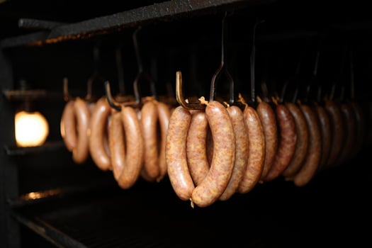 Sausages hanging inside of a smoker, ready to be cooked for a savory meal. photo