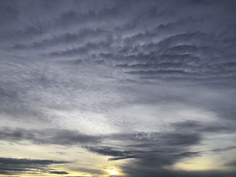 A sunset over the ocean with clouds in the sky photo